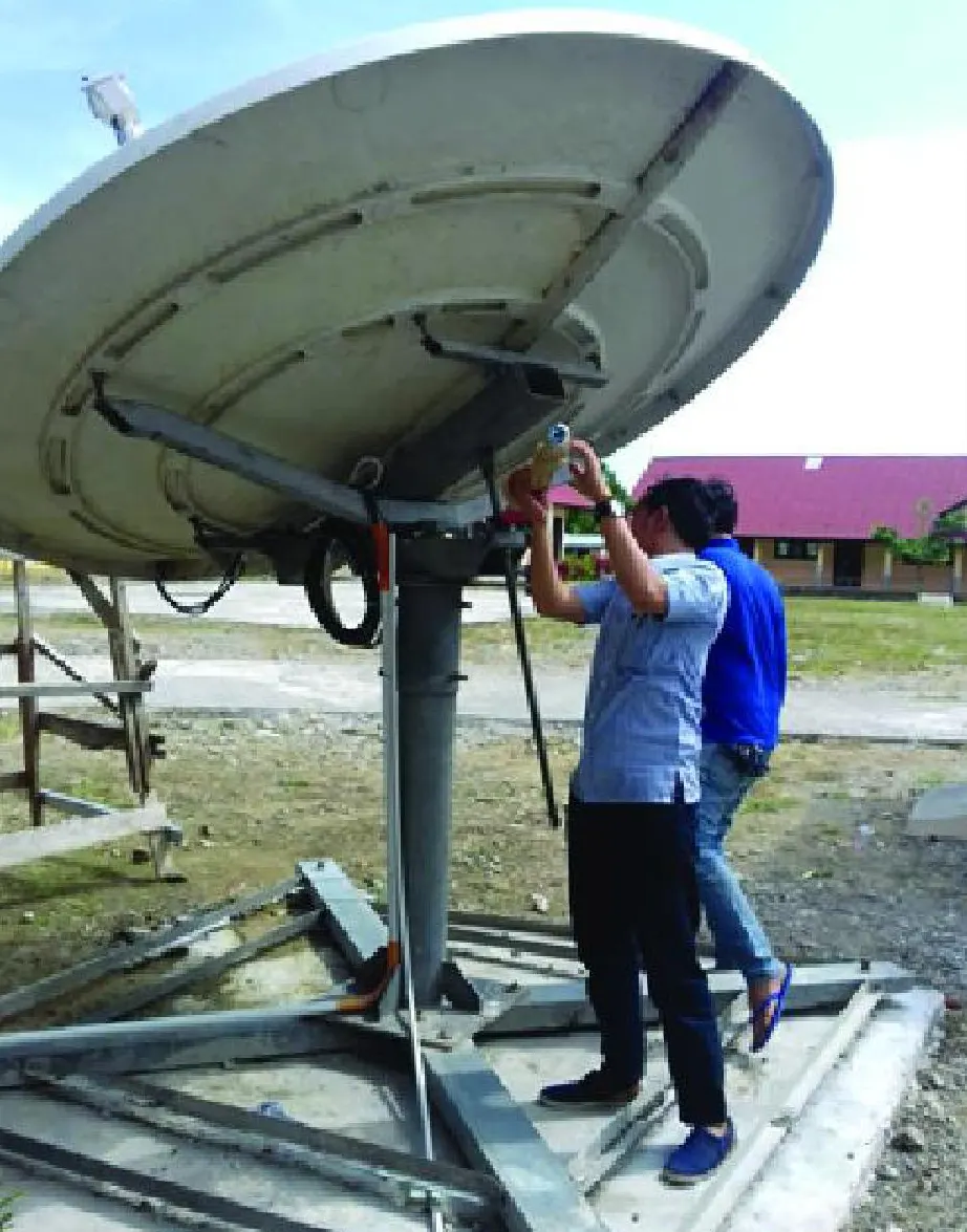 Teknisi memasang antena parabola komunikasi