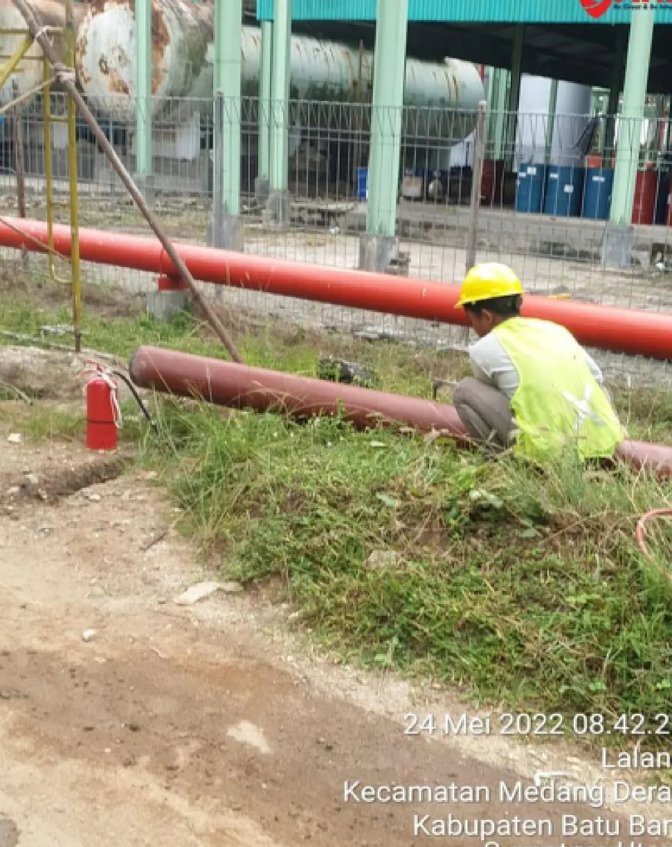 Pekerja memasang jalur pipa fire hydrant berwarna merah