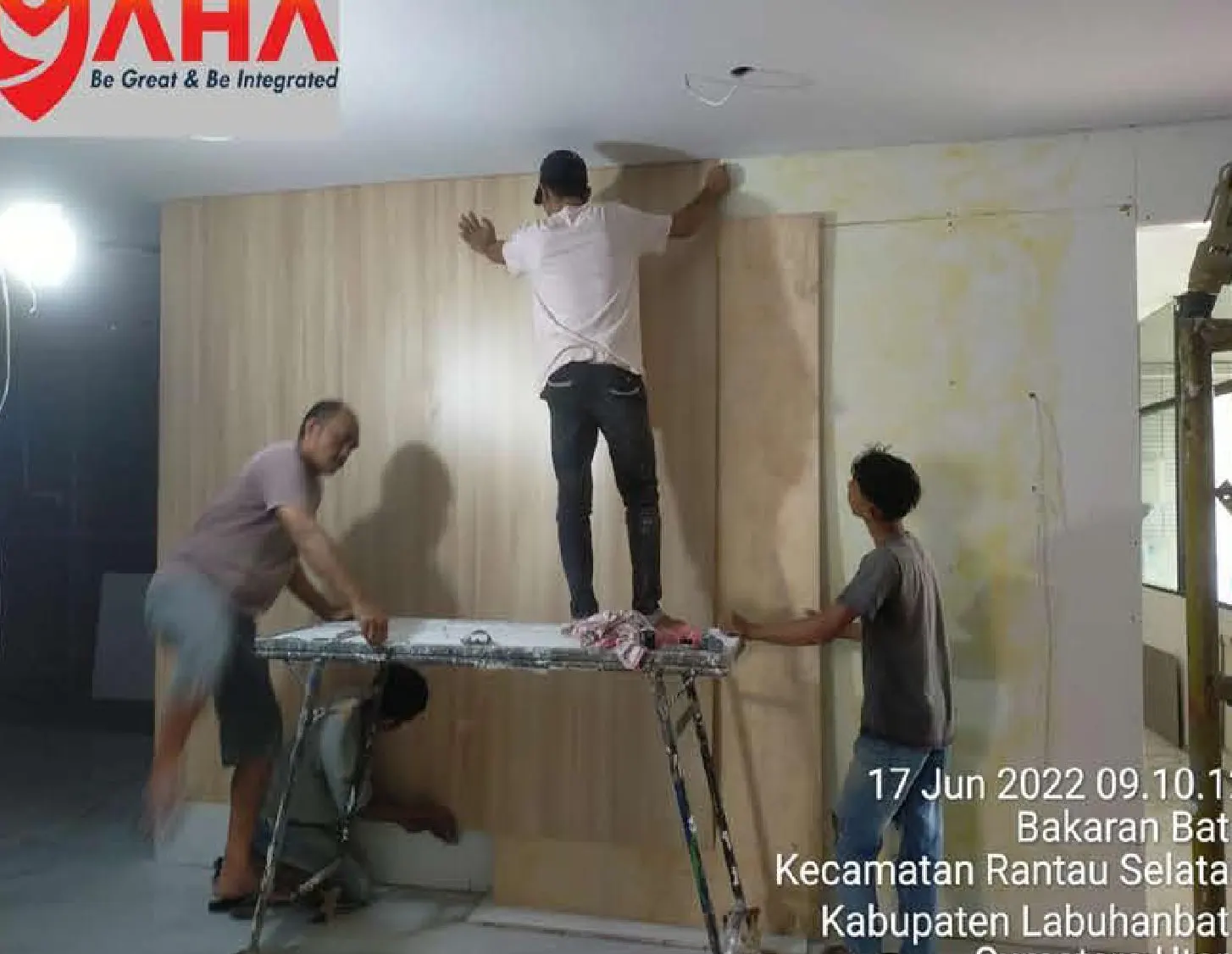 Pekerja memasang panel dinding interior kantor