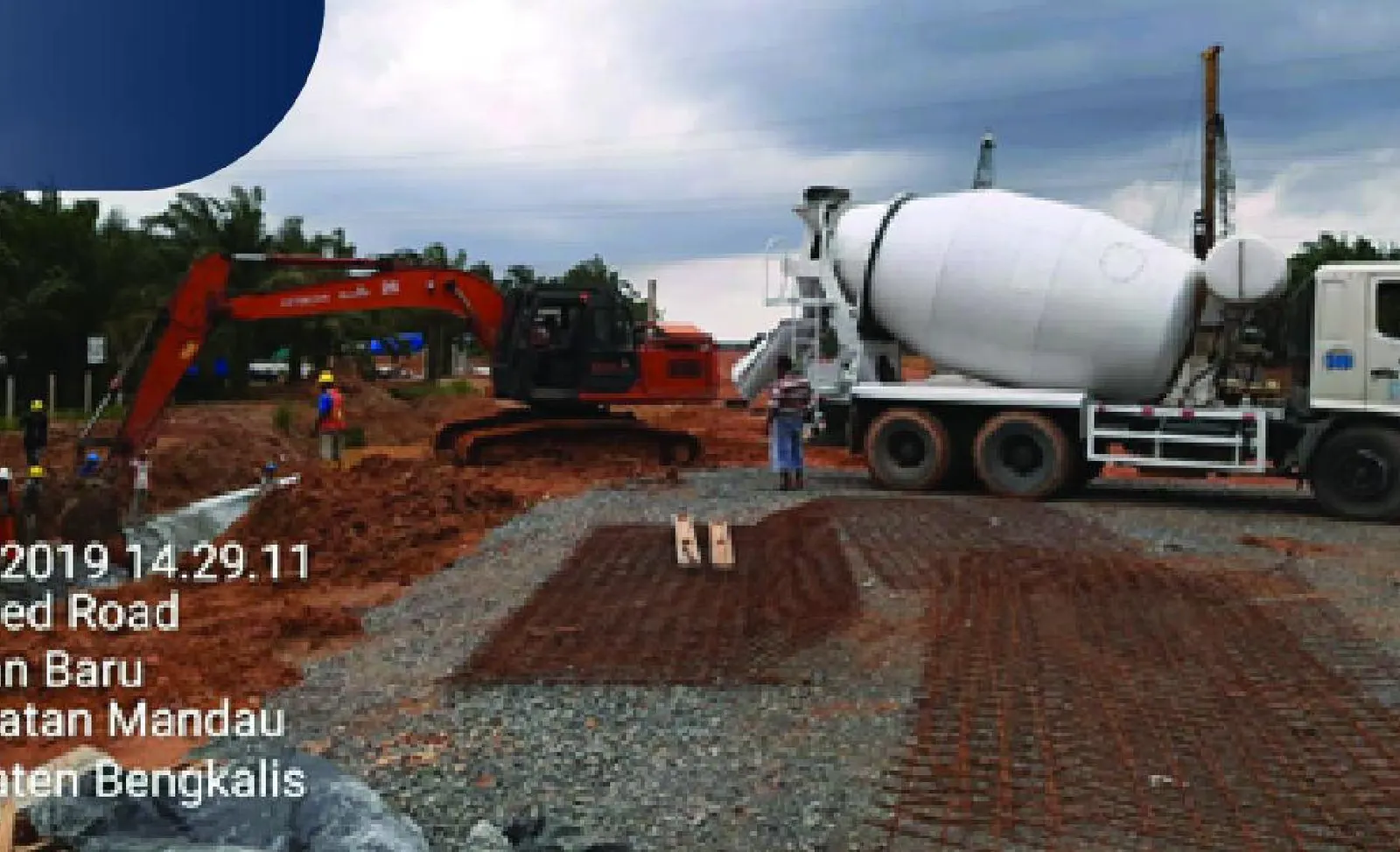 Excavator dan truk molen saat pengecoran saluran trapesium di proyek jalan tol
